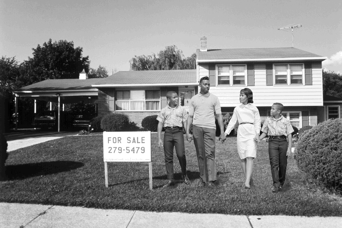 Black family in front of house with