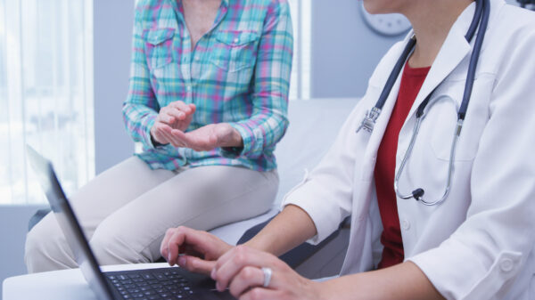 YoungDoctorAttendingtoMiddle-agedPatient-UsingLaptop-TigerShot-scaled.jpeg