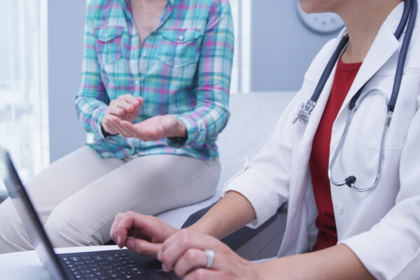 YoungDoctorAttendingtoMiddle-agedPatient-UsingLaptop-TigerShot-scaled.jpeg