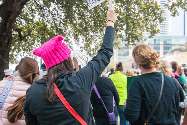 Female protesters stand with signs