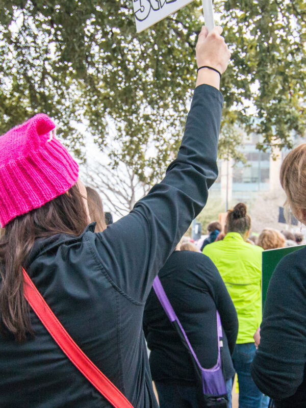Female protesters stand with signs