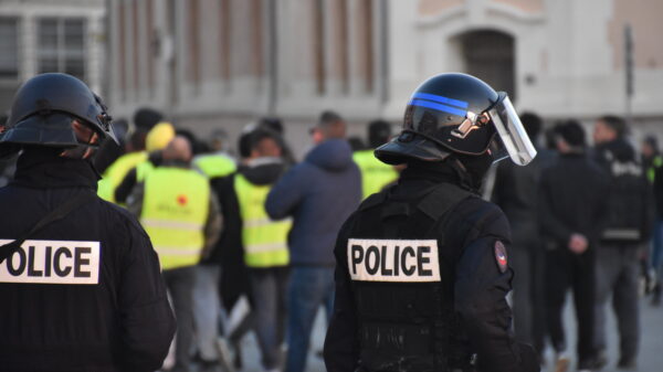 Two armed police offers standing in front of a protest