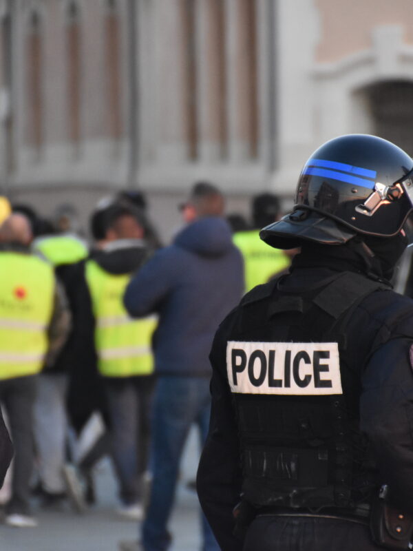 Two armed police offers standing in front of a protest