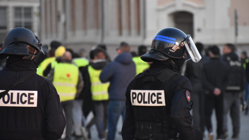 Two armed police offers standing in front of a protest