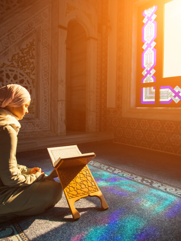 A muslim woman prays while sunlight streams in