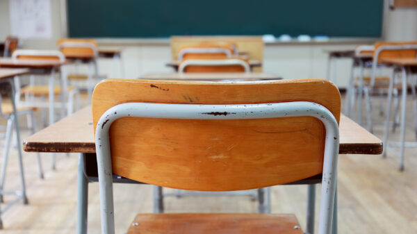 school desks in front of a chalkboard