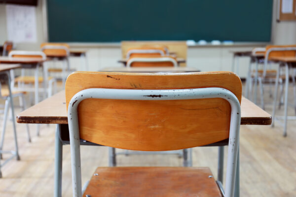 school desks in front of a chalkboard