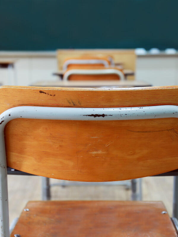 school desks in front of a chalkboard
