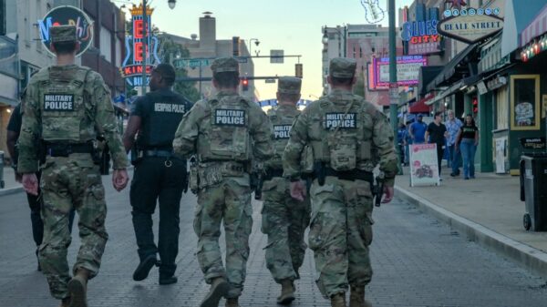Four members of the Tennessee National Guard and a Memphis Police officer walk down Beale Street in Memphis during a federal law enforcement deployment.
