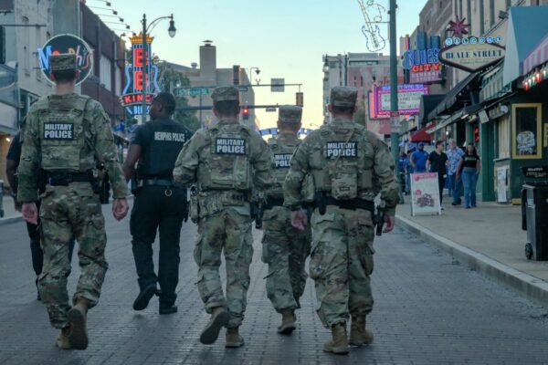 Four members of the Tennessee National Guard and a Memphis Police officer walk down Beale Street in Memphis during a federal law enforcement deployment.