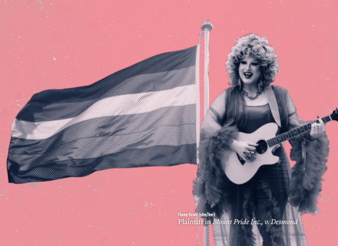 Flamy Grant, a drag queen, is against a pink background with a pride flag waving next to her