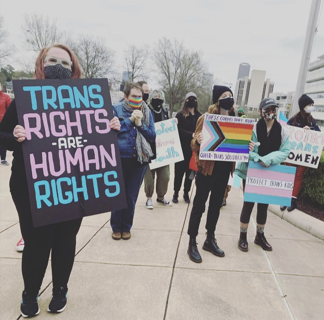People holding pro-trans signs