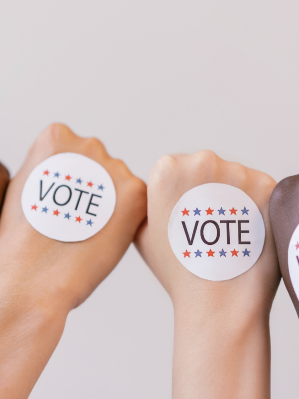 Four different fists with "Vote" stickers on them.
