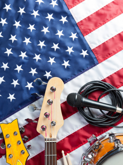 An American flag with a mic and a guitar handle resting on top of it.