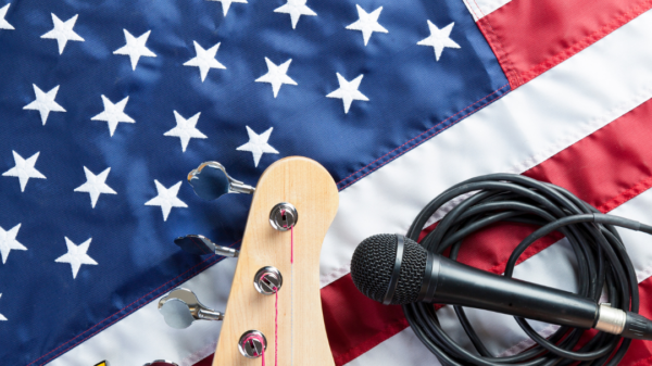 An American flag with a mic and a guitar handle resting on top of it.