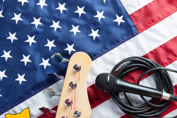 An American flag with a mic and a guitar handle resting on top of it.