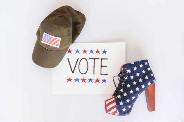 Image of a hat and a show with an American flag on each and a VOTE sign in between the two objects.