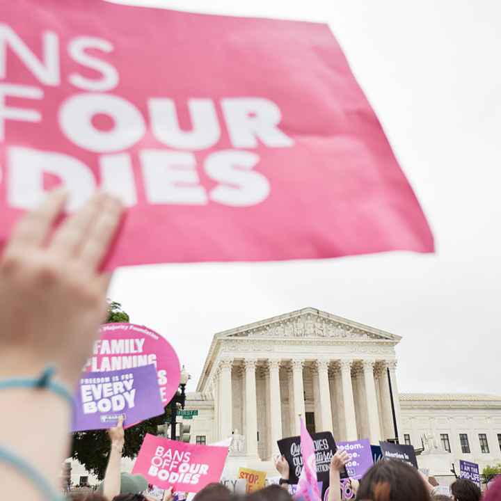 Protesters supporting abortion march in front of the Supreme Court holding signs that read "Bans off our Bodies."