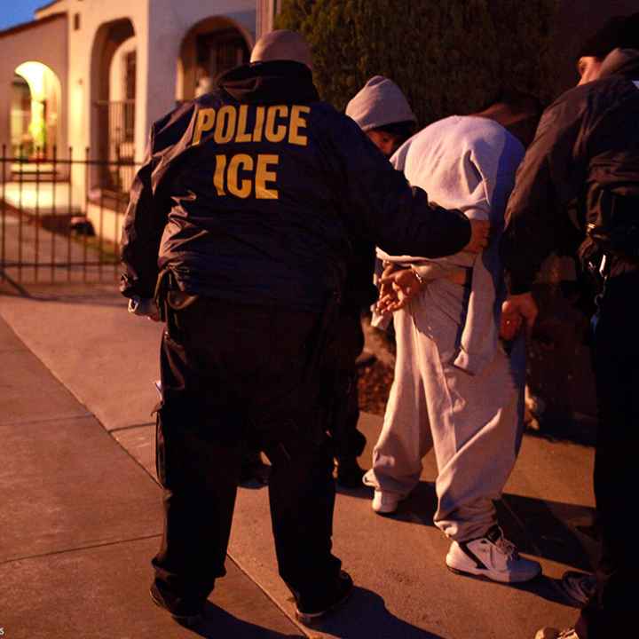 U.S. Immigration and Customs Enforcement (ICE) officers apprehending two men.